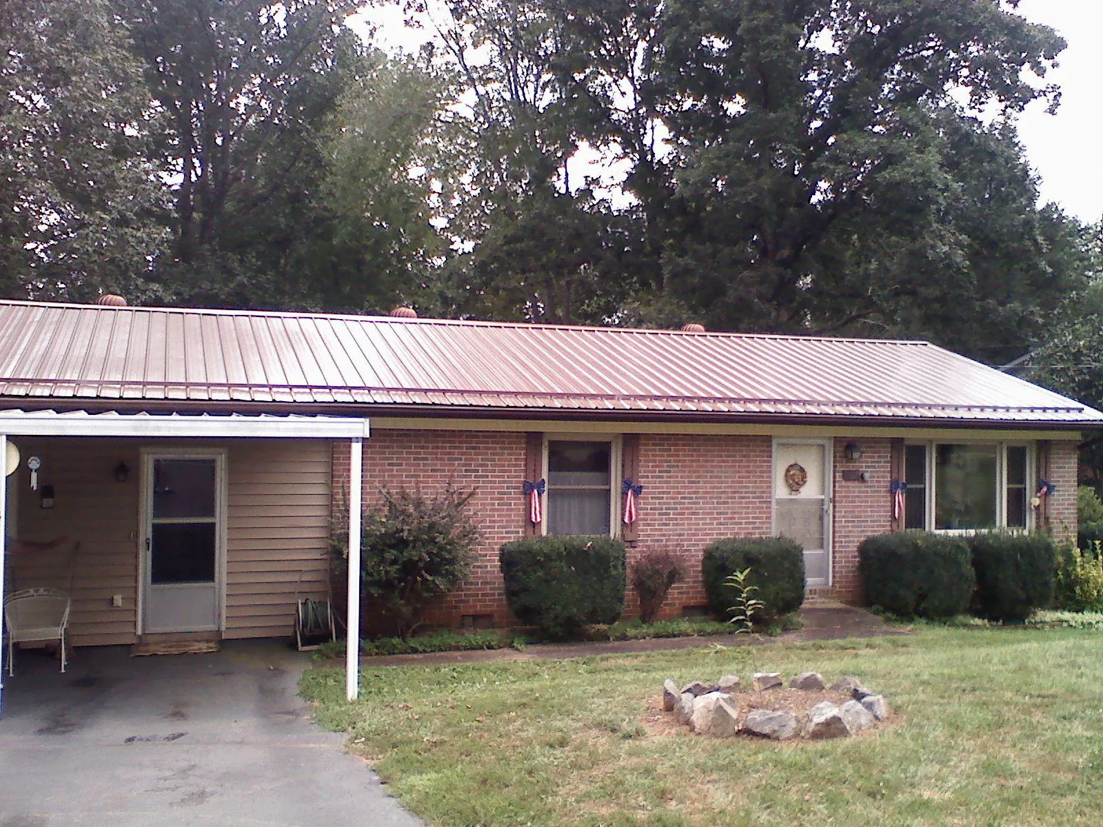 Bronze metal roof and carport on a brick ranch home — Roof Repair work by our crew in Hoffman